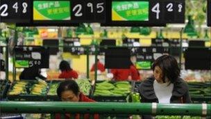 Chinese shoppers buy vegetables at a supermarket in Hefei