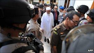 Armed anti-terror police commandos escort Abu Bakar Ba'asyir at Jakarta court on March 14, 2011