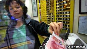 Currency exchange owner counting out Chinese yuan