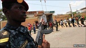 A soldier loyal to Ivorian President Alassane Ouattara watches as local recruits arrive at the former headquarters of the Republican Guard in Abidjan April 14, 2011
