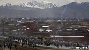 Protesters run from tear gas on a road outside La Paz, Bolivia