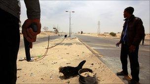 Rebel fighters are seen at the eastern entrance of Ajdabiya on 17 April