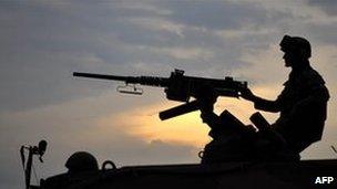 A Colombian soldiers sits atop an armoured personnel carrier (APC), in position along a road in Miranda, Cauca department, Colombia, on March 28, 2011