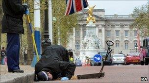 Police carry out security checks on drains and lamp posts along the Mall