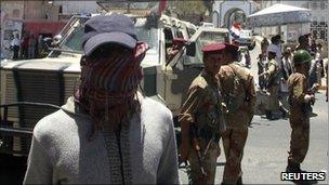 A protester walks past an army barrier in the southern city of Taiz, Yemen, 19 April, 2011