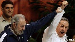 Former Cuban leader Fidel Castro (L) holds up the arm of his brother, Cuba's President Raul Castro, during the closing ceremony of the sixth Cuban Communist Party (PCC) Congress in Havana, 19 April 2011