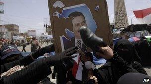 Yemeni women pelt a poster of President Saleh with their shoes, Sanaa, 17 April