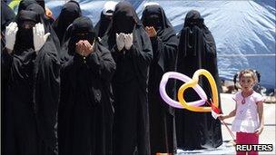 Yemeni women protesters pray in Sanaa, 12 April