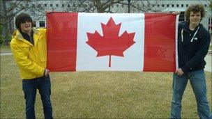 Two students holding the Canadian flag