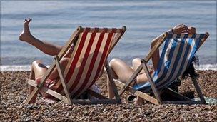 People enjoy the sunshine on the beach in Brighton, southern England