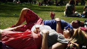 A couple relax with a drink as they enjoy the hot weather