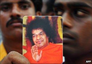 A devotee holds a picture of the late Sri Satya Sai Baba in Puttaparthi, India, 24 April