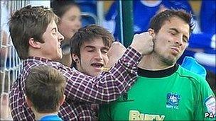 Cameron Belford surrounded after a pitch invasion