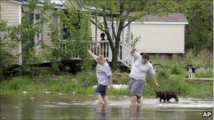 Eve Andrews, left, and her son Brandon Andrews walk through floodwater to get back to their home in Poplar Bluff, Missouri, on Monday