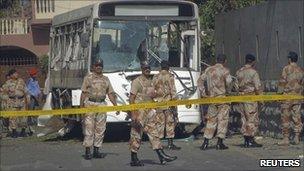 Paramilitary soldiers arrive at the scene after a bus carrying Pakistan Navy officials is hit by a bomb in Karachi on 26 April 2011