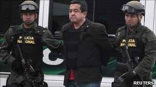 Joaquin Perez, a suspected Farc rebel is escorted by policemen after his arrival at Bogota police on 25 April, 2011