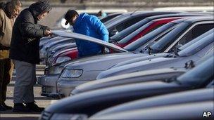 Prospective car-owners check new vehicles at a sales yard in Beijing (file image)