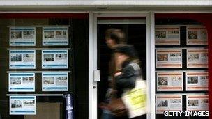 Couple walk past an estate agent