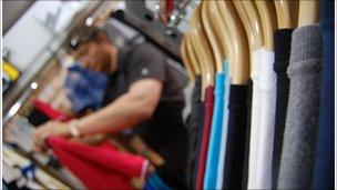 Chris Sykes hangs a red T-shirt up on the rails in his clothes shop in Hull