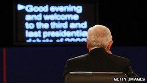 A man sitting in front of a teleprompter