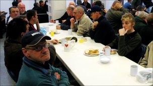 People gather around a table at the Mission