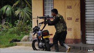 An alleged member of the Farc guerrillas aims a rifle in Cauca province on 8 April 2011