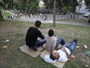 Tunisian migrants sit in a Paris square, 26 April