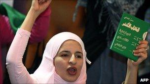 Pro-Gadaffi supporter holds up the Green Book in Tripoli on 7/4/11