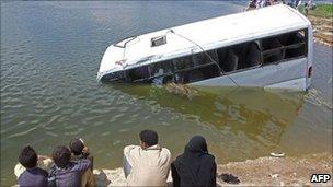 Egyptians look at a sunken minibus in the Nile river in Beni Suef, Egypt, 29 April 2011.