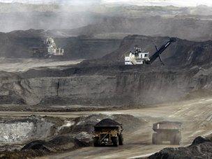 File photo: Mining trucks carry loads of oil laden sand after being loaded by huge shovels at the Albian Sands oils sands project in Ft. McMurray, Alberta, Canada