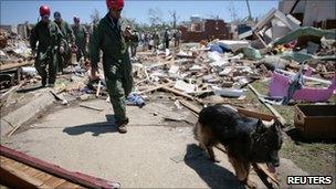 Rescue workers search rubble in the town of Tuscaloosa in Alabama