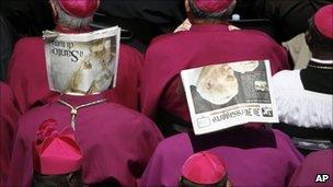 Bishops shield their heads from the sun with newspapers during the beatification ceremony for late Pope John Paul II at the Vatican