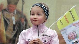 A girl holding flag with an image of John Paul II in Wadowice, southern Poland, on 1 May 2011