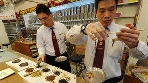 Workers at a traditional chinese medicine store prepare various dried items at a shop in Hong Kong