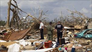 Police and fire fighters search the Rosedale community in Tuscaloosa, Alabama on Monday