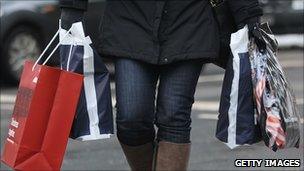 A woman carries shopping bags