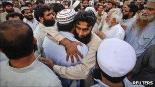 Supporters of the banned Islamic organization Jamaat-ud-Dawa embrace each other after taking part in a funeral prayer for al Qaeda leader Osama bin Laden in Karachi May 3, 2011.