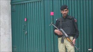 A Pakistani policeman stands guard at the Bin Laden compound in Abbottabad