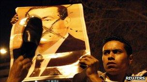 Anti-Mubarak protesters deface a picture of the former president. Photo: April 2011