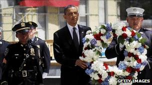 President Barack Obama (left) carries a wreath in New York