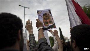 An Iranian student holds upside down a portrait of Bahrain's King Hamad bin Issa al-Khalifa with a red "X" drawn across it during a protest outside the Bahrain embassy in Tehran on 30 April 2011