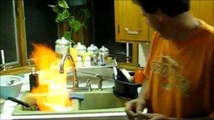 Video footage of man appearing to set alight water from a tap (Image taken from YouTube)