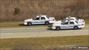 Police vehicles parked near Gilgo Beach