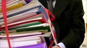 Man holding papers tied together with red tape