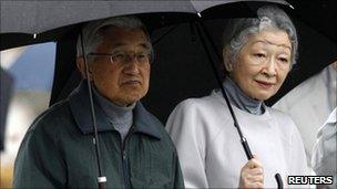 Japan's Emperor Akihito (L) and Empress Michiko visit at an area devastated by the 11 March tsunami in Fukushima prefecture