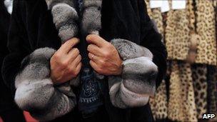 Customer trying on fur coat in Paris - file pic