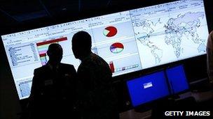 Government workers stand in front of a screen at the Department of Homeland Security