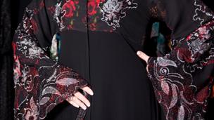 A red and black abaya with flowers patterns and lace