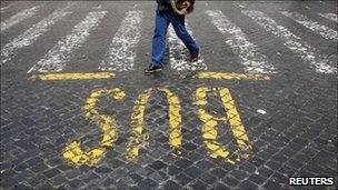 A man walks past a bus sign painted on a street in Rome (archive image)
