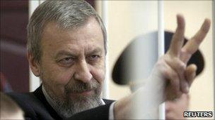 Andrei Sannikov gestures in a guarded cage during a court hearing in Minsk, May 14, 2011